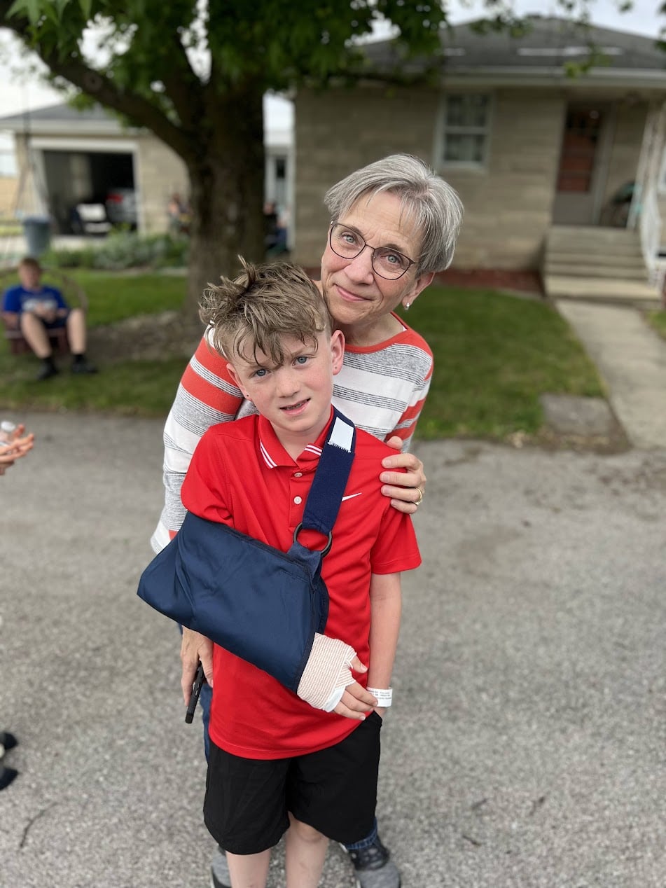 Elizabeth outside her home with her grandson